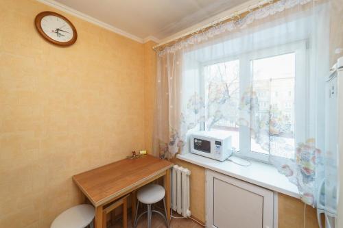 ケメロヴォにあるApartments na Tukhachevskogo 2のキッチン(テーブル、電子レンジ付)、窓が備わります。