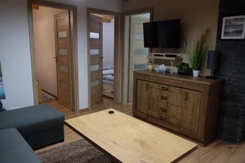 a living room with a couch and a tv at Chatka pod Stinskou in Zboj