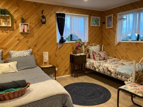 a room with two beds and a couch and windows at Winganah Cottage in Murdunna