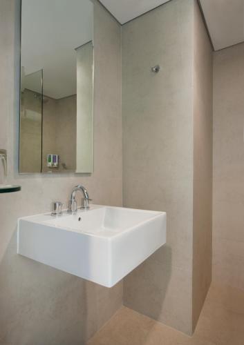 a bathroom with a white sink and a mirror at Amaris Hotel Darmo Surabaya in Surabaya