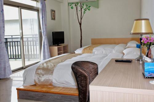 a hotel room with a bed with a desk and a bed sidx sidx sidx sidx at Maple Feeling Vacation Farm in Guangfu
