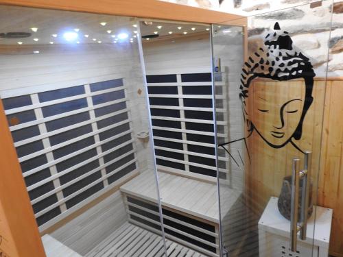 a shower with a face painted on the wall at Le Barriol in Saint-Julien-Chapteuil