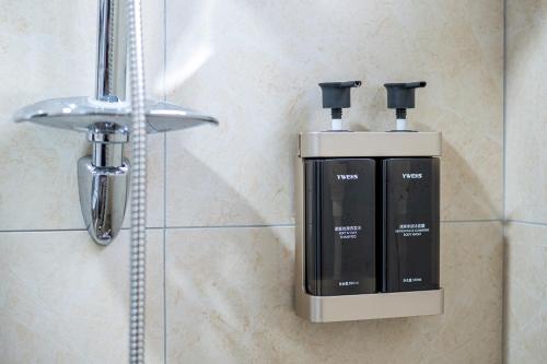 a soap dispenser on a wall in a bathroom at Muxuan Homestay in Yuli