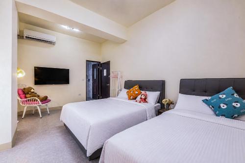 a bedroom with two beds and a tv at Muxuan Homestay in Yuli
