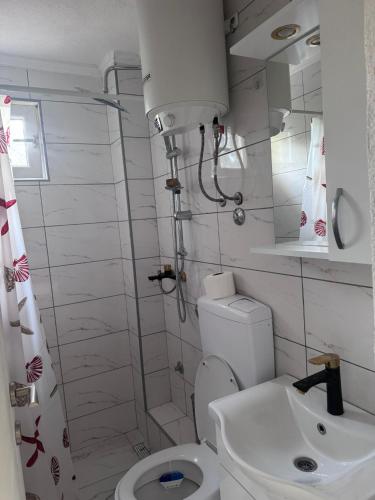 a white bathroom with a toilet and a sink at Rafting Kamp Dvije Vrbe in Foča