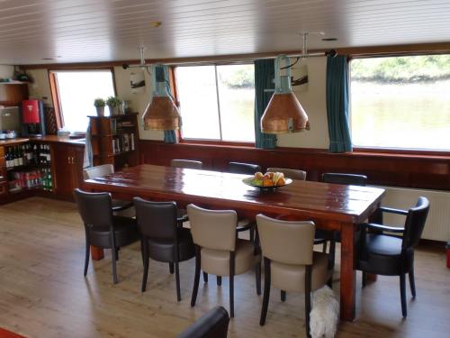 a dining room with a wooden table and chairs at Hotelboat Fiep in Amsterdam