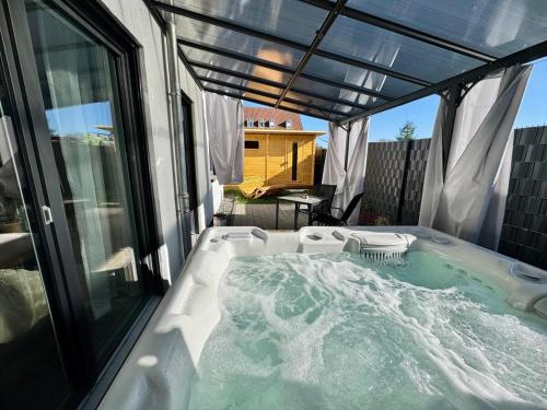 a jacuzzi tub on a patio with an umbrella at Zuri Suite in Rittersdorf