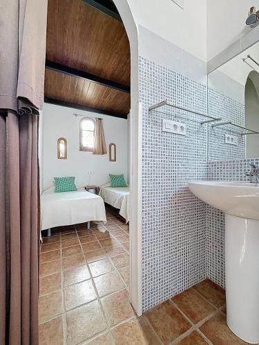 a bathroom with a sink and a bed in a room at Torre Santo Dios in Iznájar