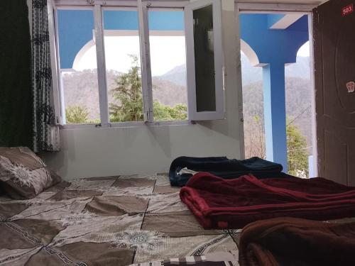 a room with a view of a mountain through a window at Dev Giri Guest House in Phata