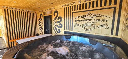 a hot tub in a room with a sign on the wall at Apartament u Krupy z Prywatnym Jacuzzi i tarasem Widokowym in Murzasichle