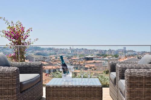a patio with wicker chairs and a table with a view at Acta The Avenue in Porto