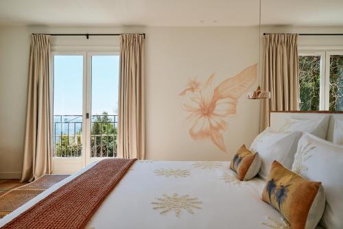 a bedroom with a large bed with a large window at Bastide Saint-Honorat in Grasse