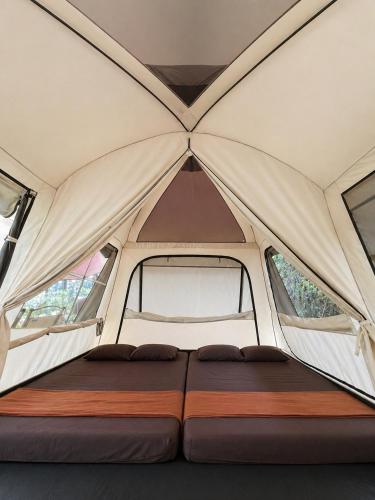 a bed in the middle of a tent at serlok glamping in Tangkubanperahu