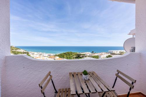 a bench on a balcony with a view of the ocean at incredible view- T1 Salema in Salema