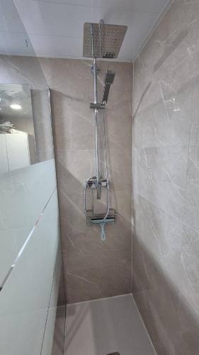 a bathroom with a shower with a shower head at Comarruga Playa in Comarruga
