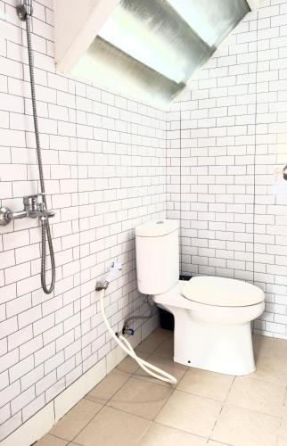 a white bathroom with a toilet and a shower at Villa W-5 Villa Private Pool Lembang, Bandung in Bandung