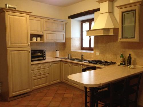 una cocina con armarios blancos y una isla de cocina en Il Fienile, en Barete