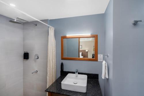 a bathroom with a sink and a mirror at Hotel Imphal by the Classic in Imphal