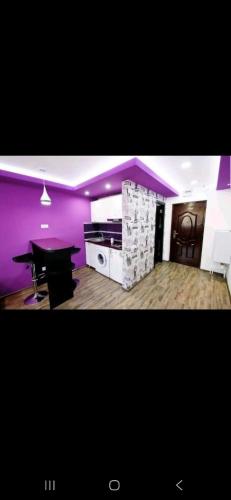 a living room with a piano and a purple wall at Tiglina in Galaţi