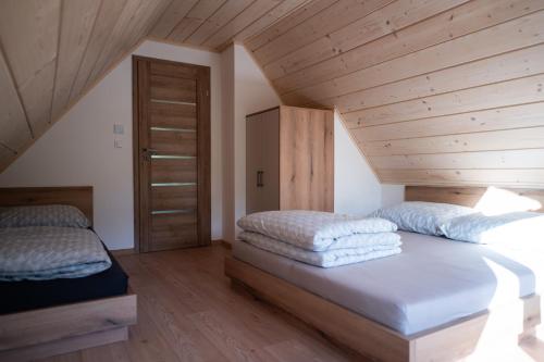 a bedroom with two beds and a wooden ceiling at Chata Rosa in Námestovo