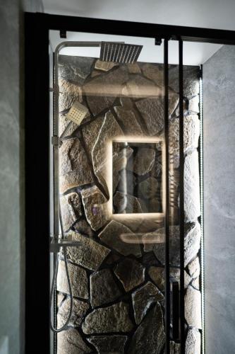 a glass door with a stone wall behind it at Chata Rosa in Námestovo