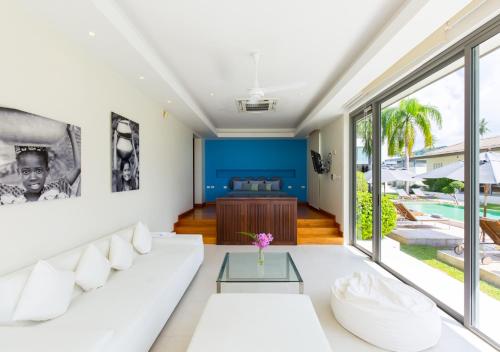 a living room with a white couch and a table at Baan Asan in Taling Ngam Beach