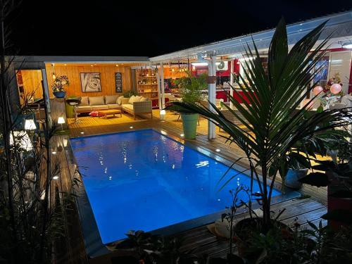 a large swimming pool in a backyard at night at Le coin des romarins in Saint-André