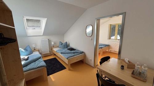 a room with two beds and a table and a mirror at Horská chata Libín in Prachatice