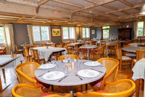 a dining room filled with tables and chairs at Hotel Restaurant de charme La Lozerette - Proche Florac in Cocurès