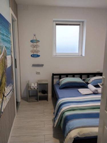 ein Schlafzimmer mit einem Bett und einem Fenster in der Unterkunft Studio Casa Katiușa in Jurilovca