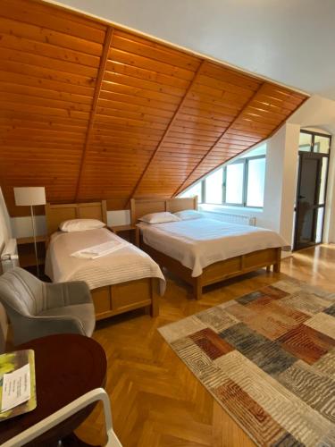 a bedroom with two beds and a wooden ceiling at Pensiunea Imperial in Târgu-Mureş