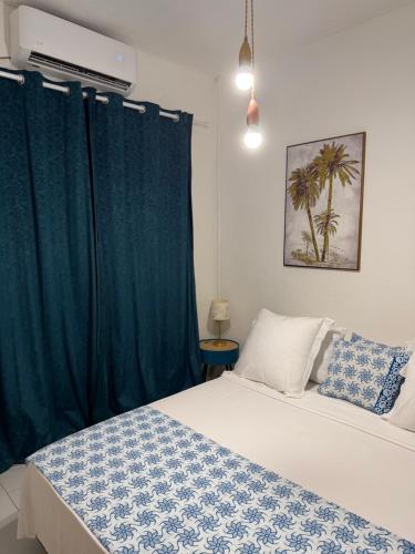 a bedroom with a bed with a blue curtain at Kaz KAFE in Mamoudzou