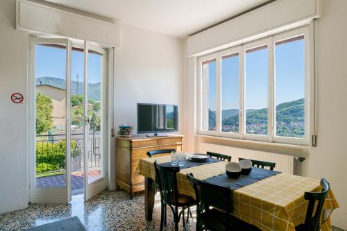 a dining room with a table and some windows at ComoVà in Maslianico