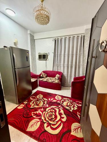 a kitchen with a refrigerator and a red rug at Center Apartment in Aswan