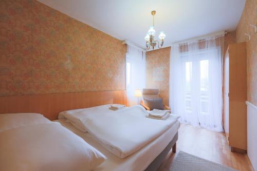 a bedroom with two beds and a window at Cosy Vintage House Bled in Bled