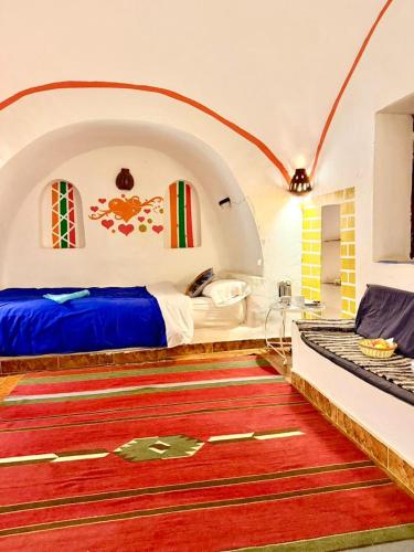 a bedroom with a bed and a red rug at Al Baeirat Hotel in Luxor