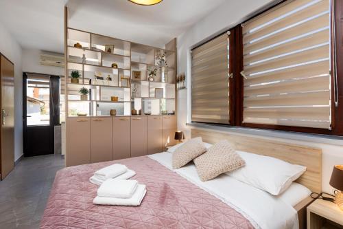 a bedroom with a large bed with towels on it at City center studio apartment in Malinska