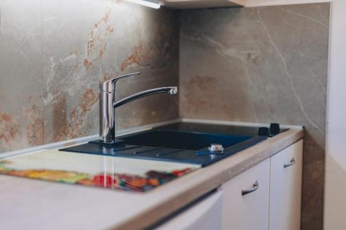 a kitchen sink with water coming out of it at City center studio apartment in Malinska