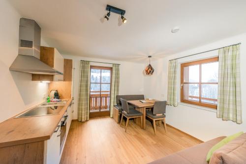 a kitchen and living room with a table and chairs at Apartments Frechhof in Schladming