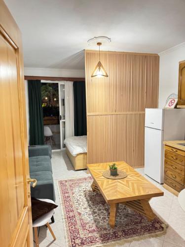 ein Wohnzimmer mit Couchtisch und eine Küche in der Unterkunft Studio Astir in Tirane