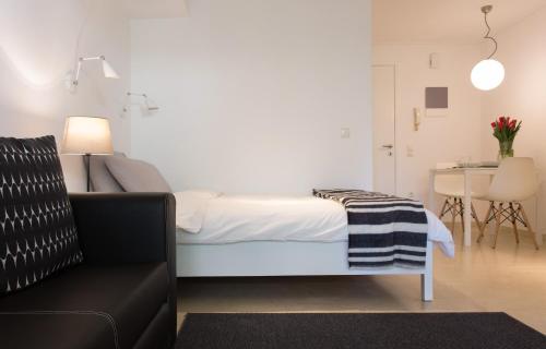 a bedroom with a bed and a table and a couch at Homz Studios Faliro in Athens