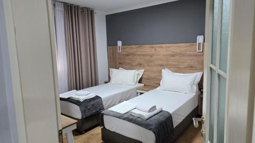 a hotel room with two beds and a mirror at AA Tirana Center View in Tirana