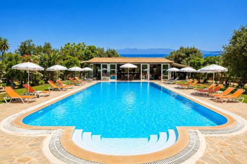 a large swimming pool with chairs and umbrellas at Kosmas Apartments in Roda