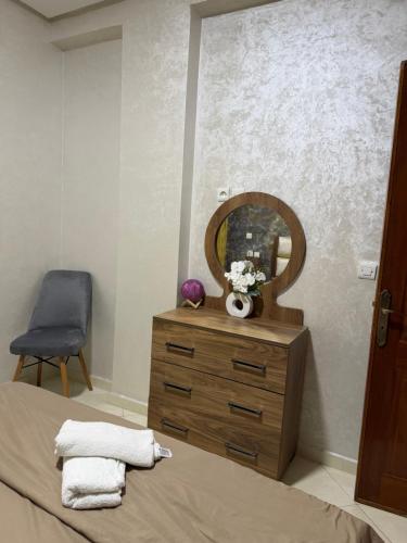 a bedroom with a bed and a mirror and a dresser at Home louah in Fez
