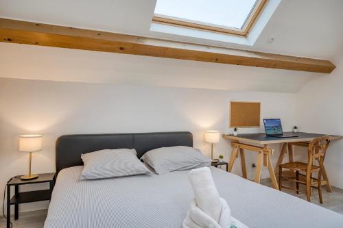 a bedroom with a bed and a desk with a laptop at COLIVING - bedroom Salon & TV in Saint-Jean-de-Gonville