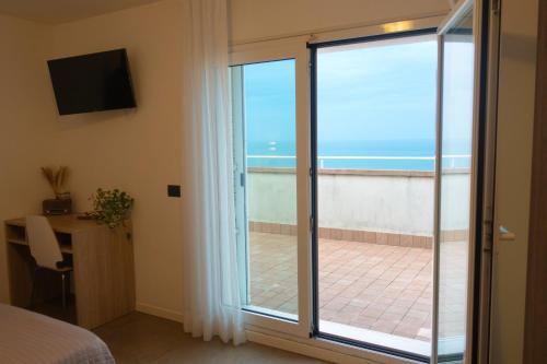 a room with a sliding glass door with a view of the ocean at Hotel Nemo in Misano Adriatico