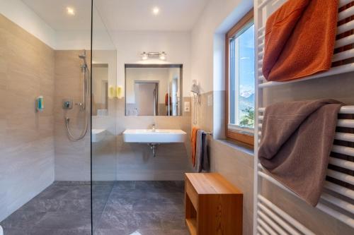 ein Badezimmer mit Waschbecken und Dusche in der Unterkunft Hotel Chavalatsch in Taufers im Münstertal