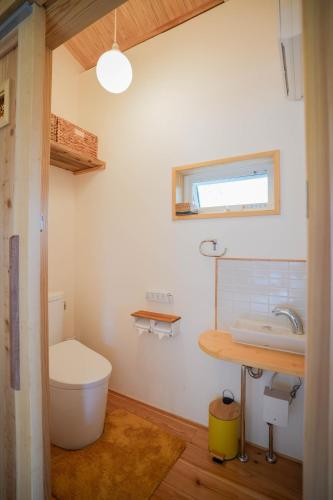 a bathroom with a toilet and a sink at 丘の上の小さなスローリゾート フェニックスの宿 in Miyazaki