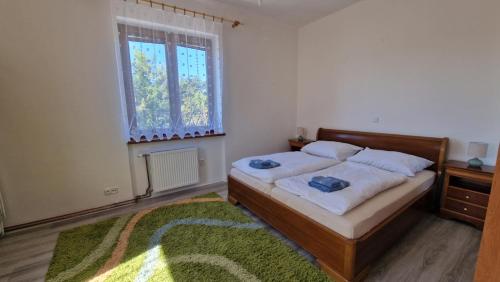 a bedroom with a bed and a window and a rug at Apartment LAURA in Žilina