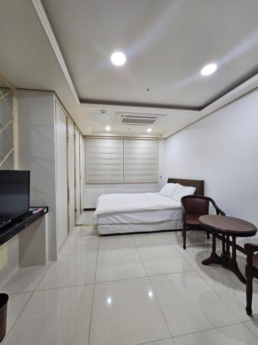a bedroom with a bed and a table and a tv at 인터시티365호텔 in Seoul